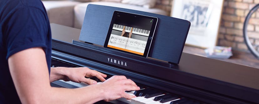 IPad with flowkey on a black piano