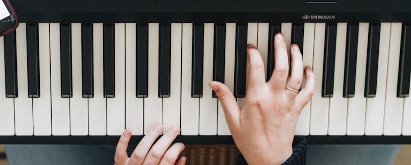 zwei Hände auf einem Klavier von Yamaha