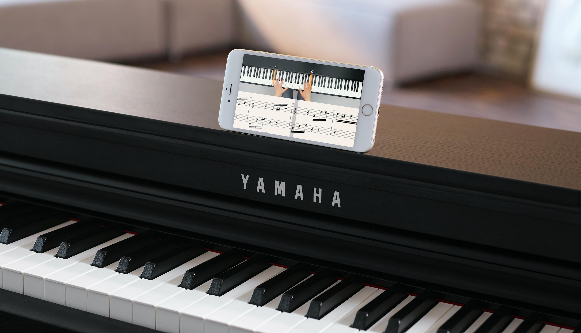 black Yamaha piano and a smartphone with flowkey