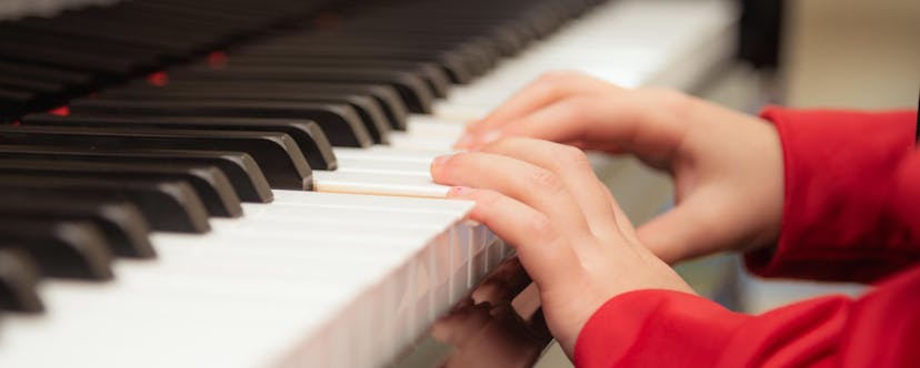 Children hands on a piano