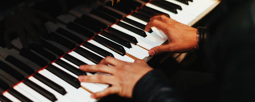 Two hands on a Yamaha piano