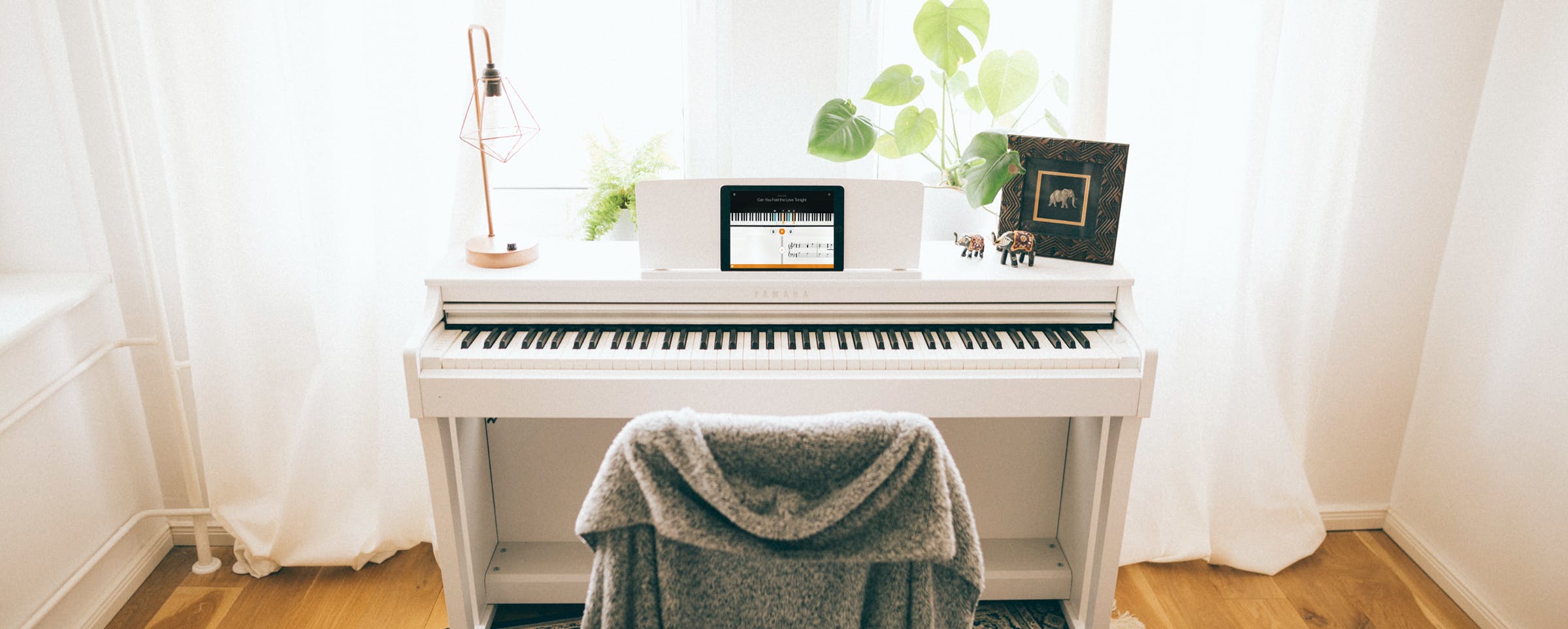 White Yamaha piano with an iPad