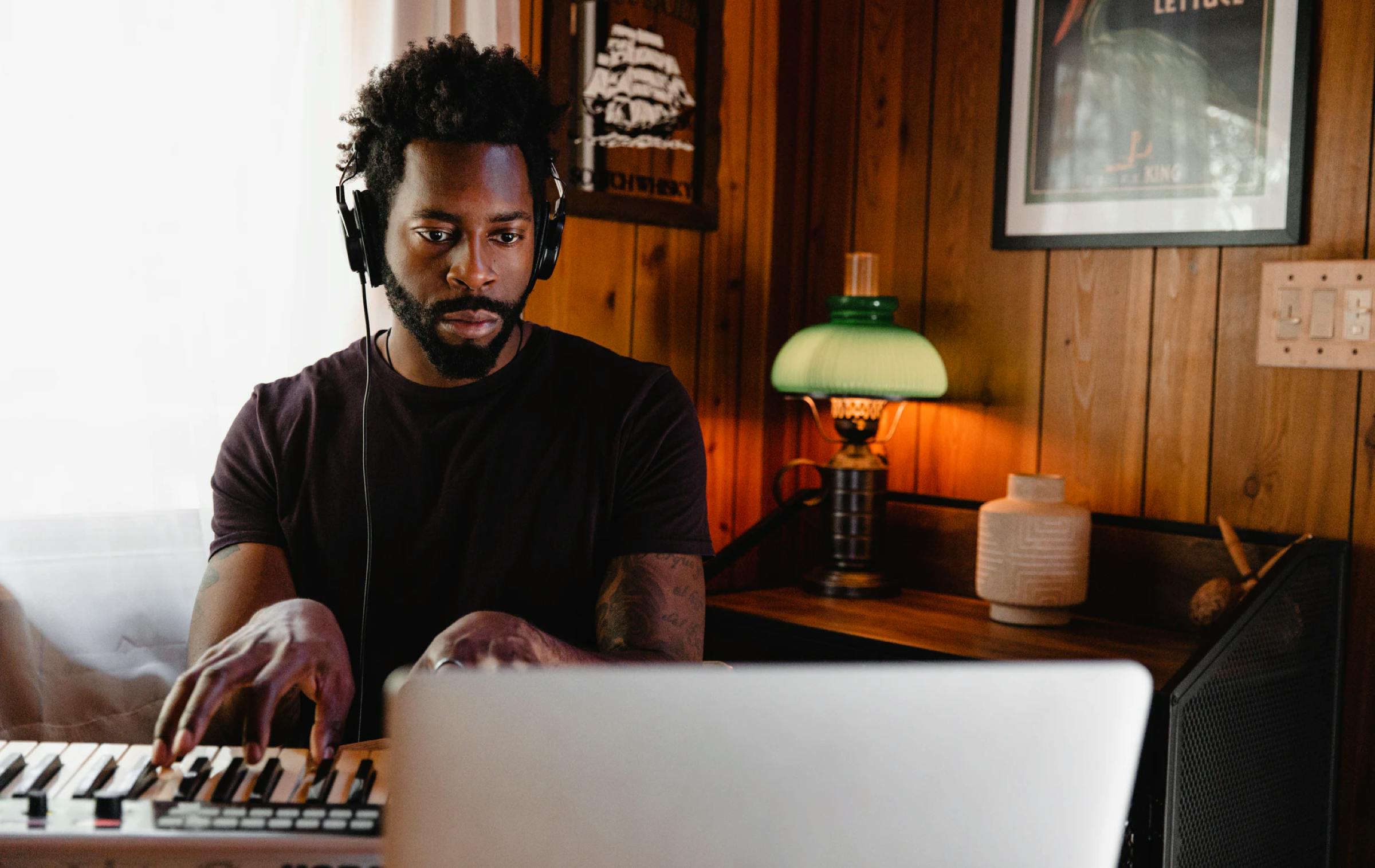 Man playing keyboard while looking at a notebook