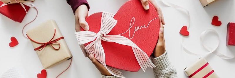Ein roter Karton in Herzform mit "love" Schriftzug 