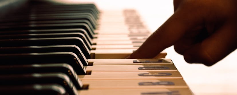 Un doigt presse une touche sur le clavier de piano