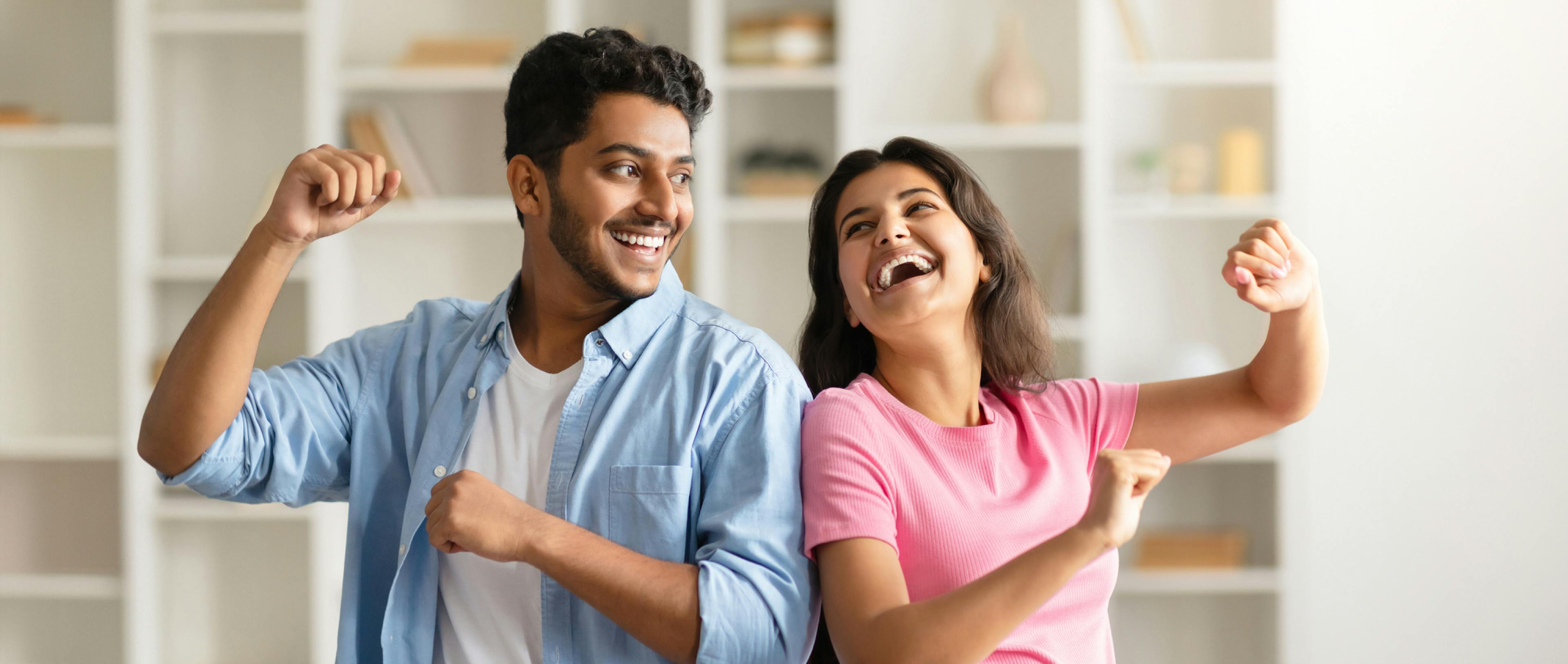 A man and woman looking happy while they dance