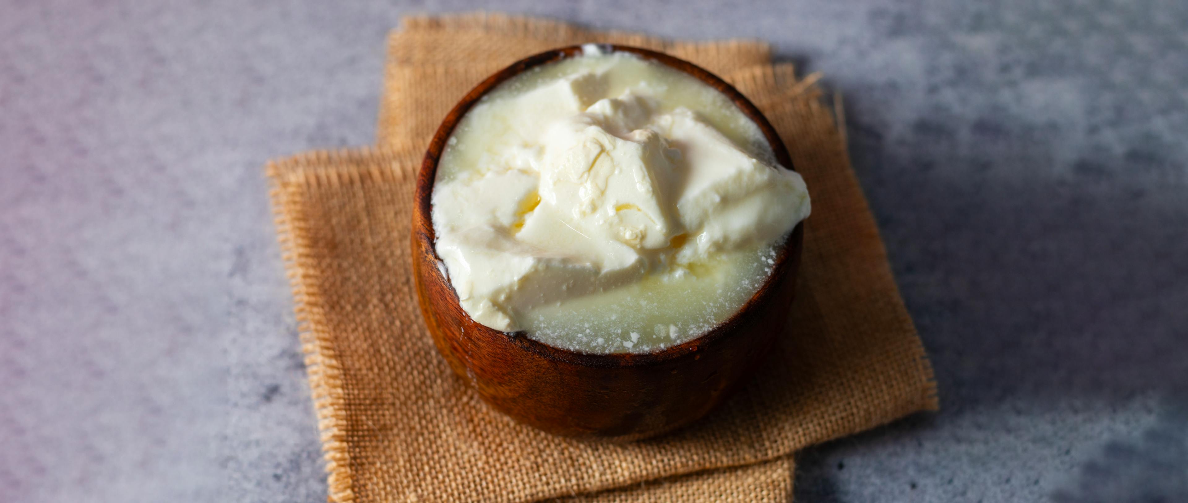 A bowl of curd on a brown cloth.