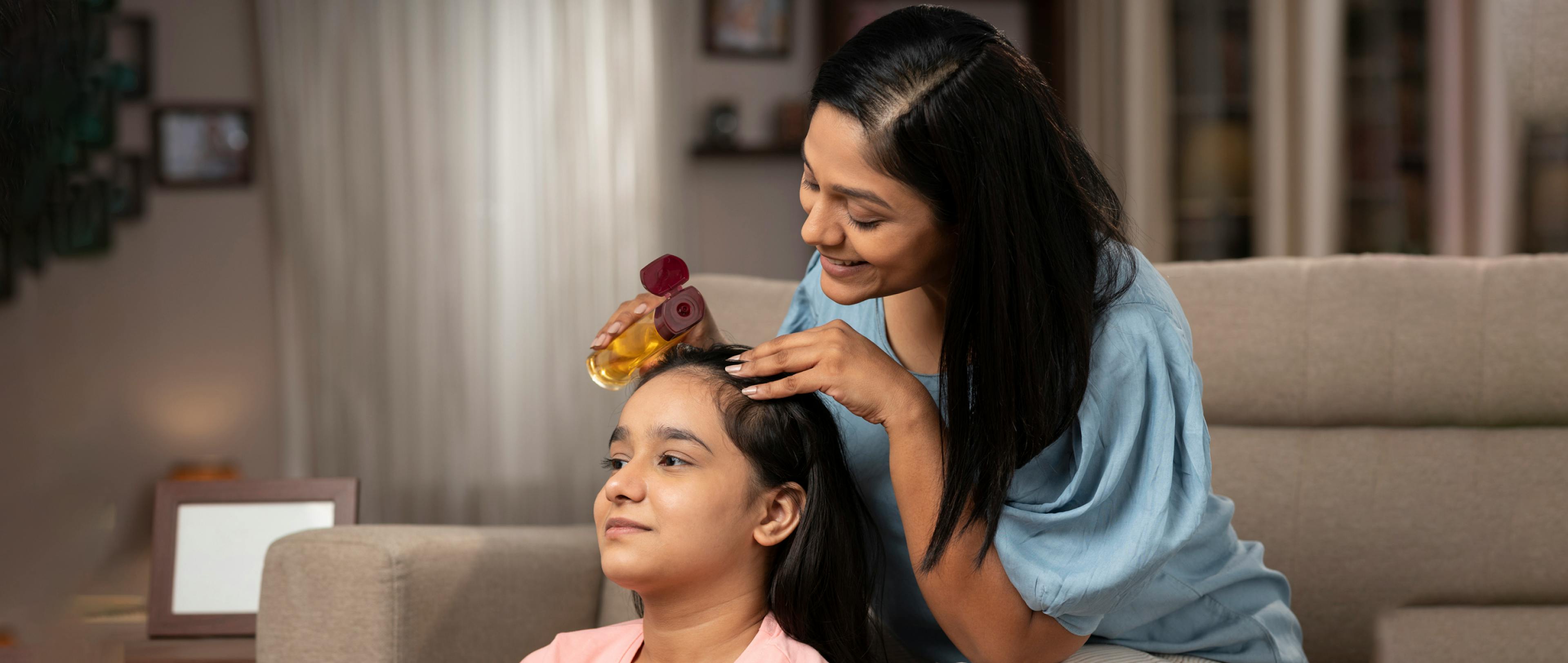 Mother giving head massage to daughter