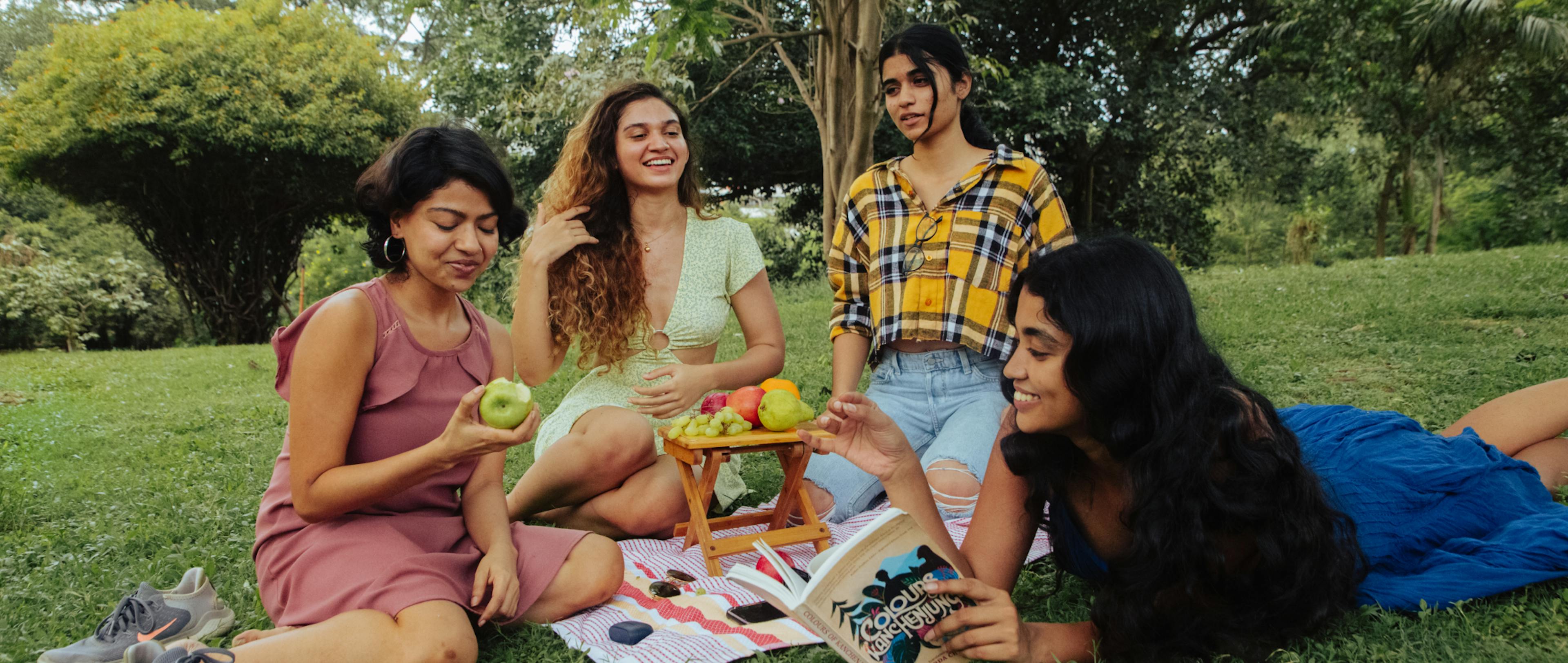 A group of girls with glowing skin eating healthy foods that help with nutrition for their skin.