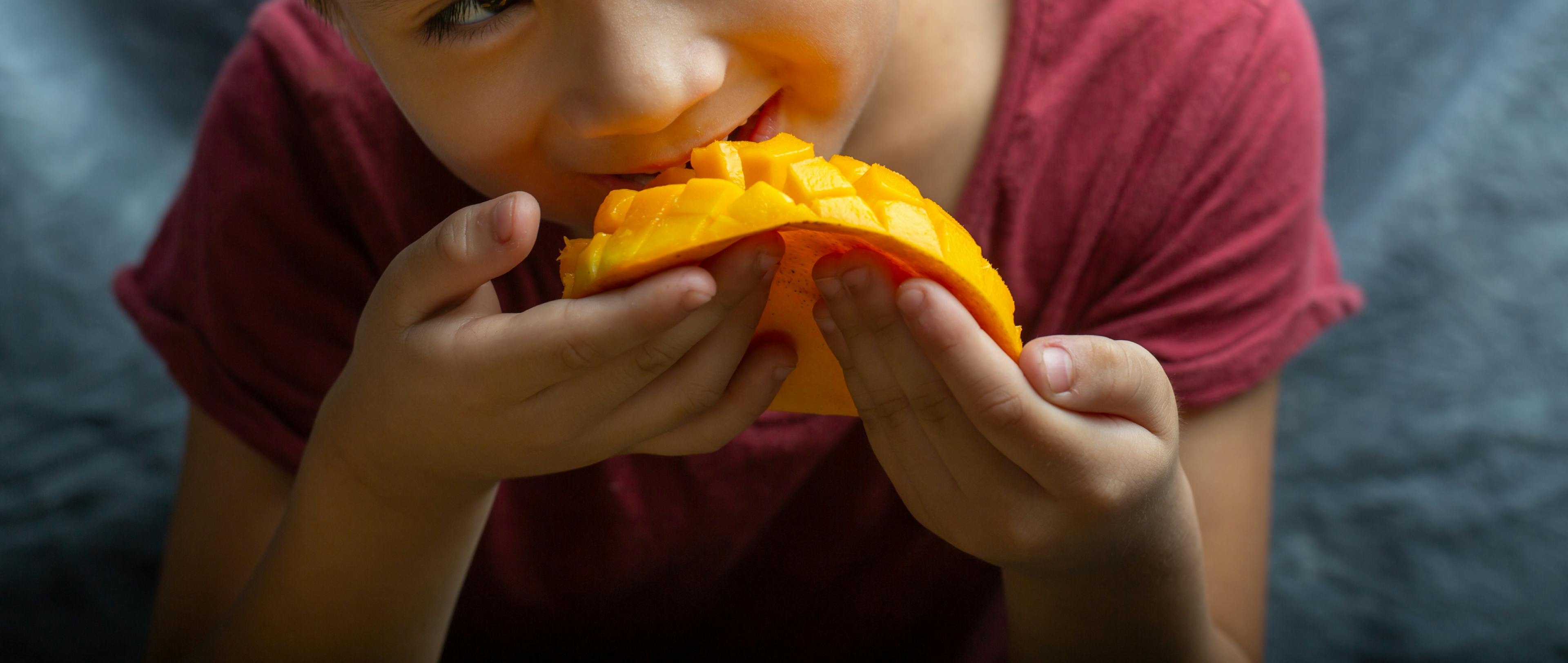 A visual of a boy enjoying the benefits of mango in summer.