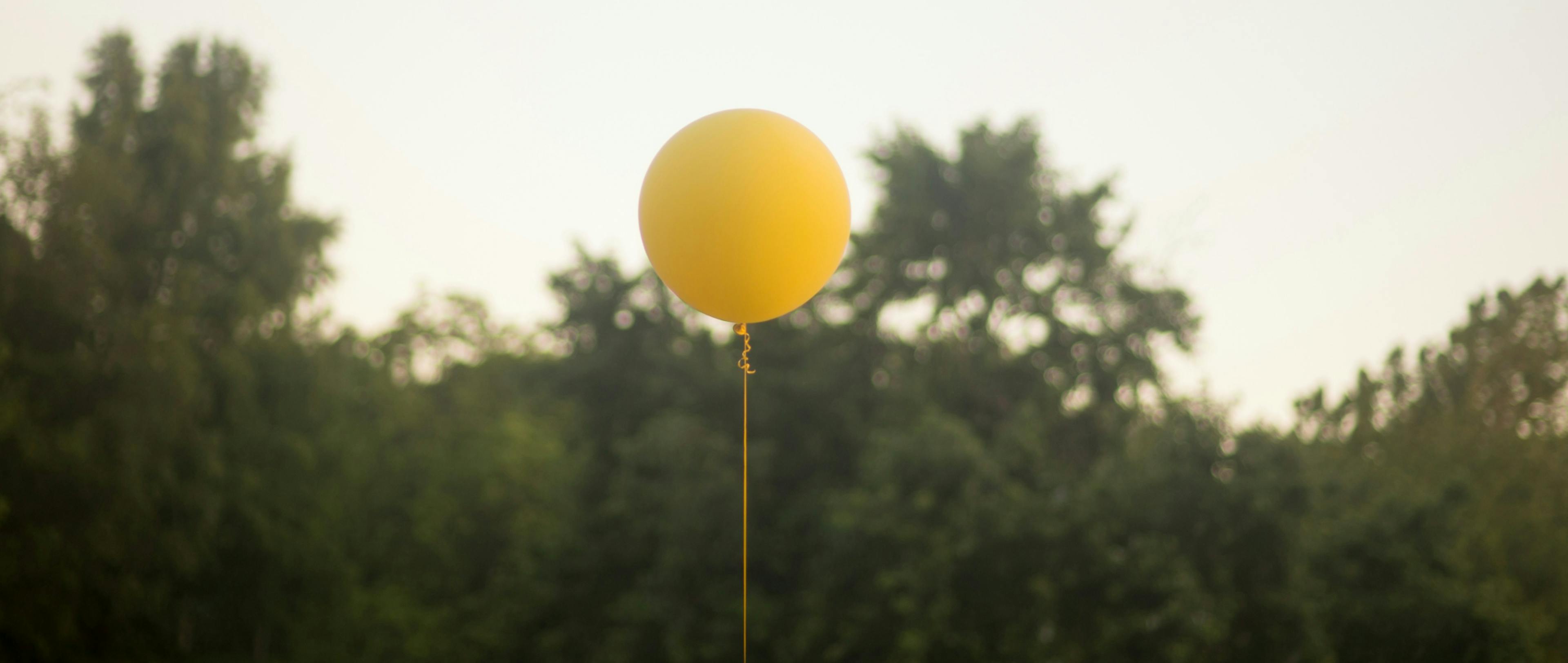 A yellow balloon floating in the air.