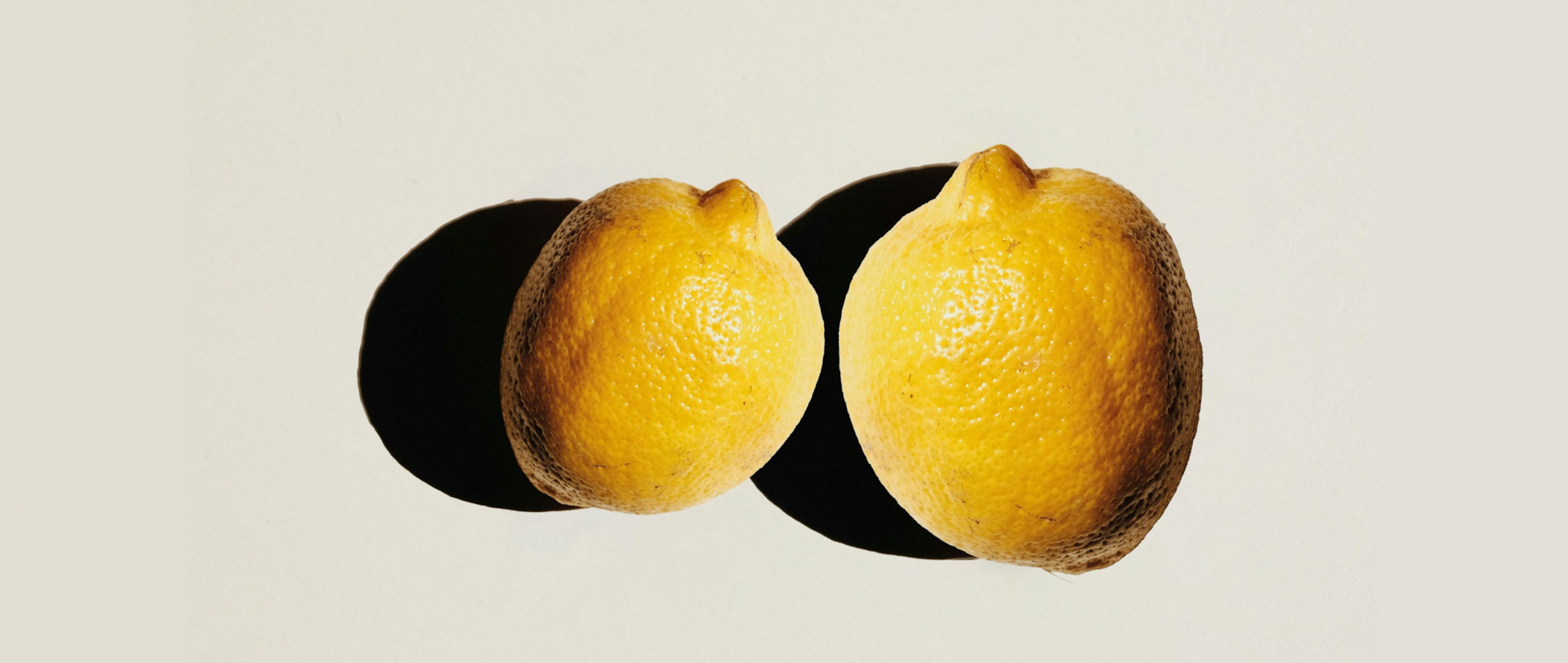 Two lemons of different sizes placed side by side.