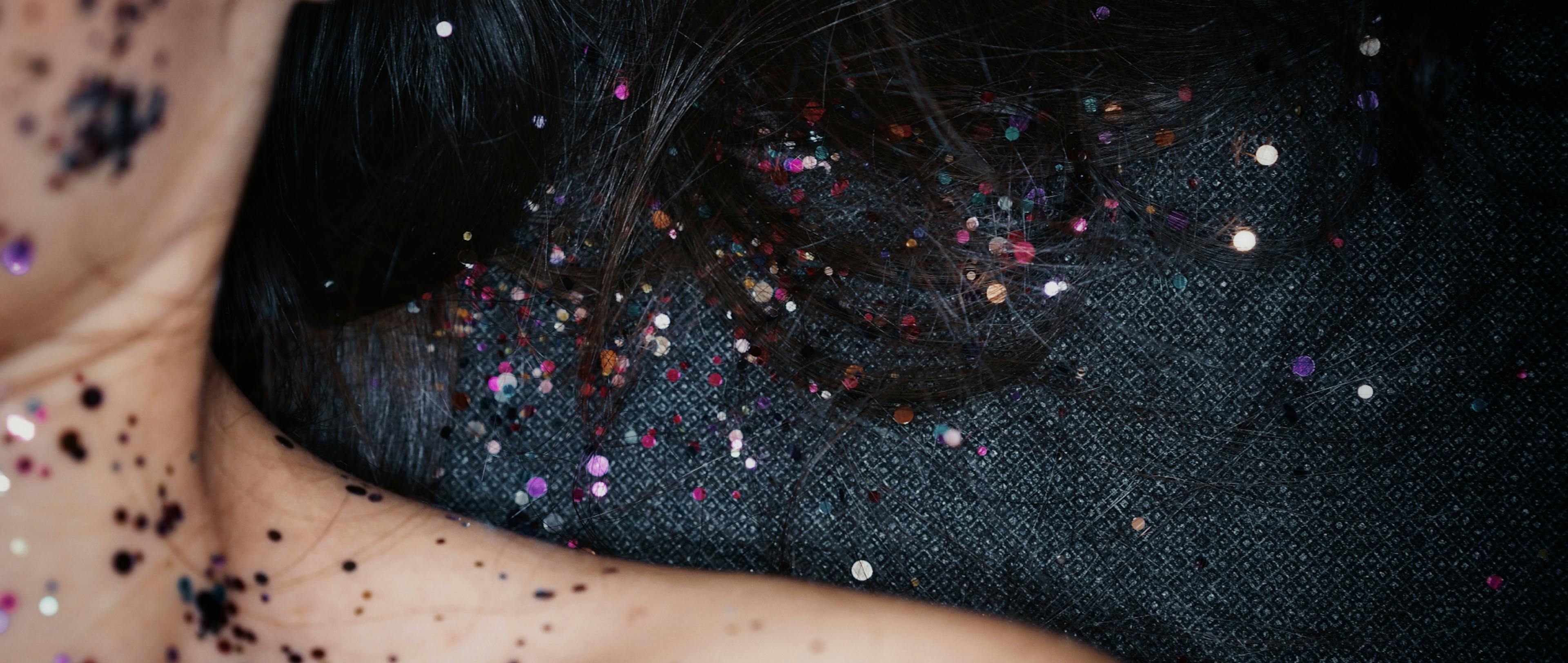 Sparkle is sprinkled over a girl and her hair that represents dandruff. 