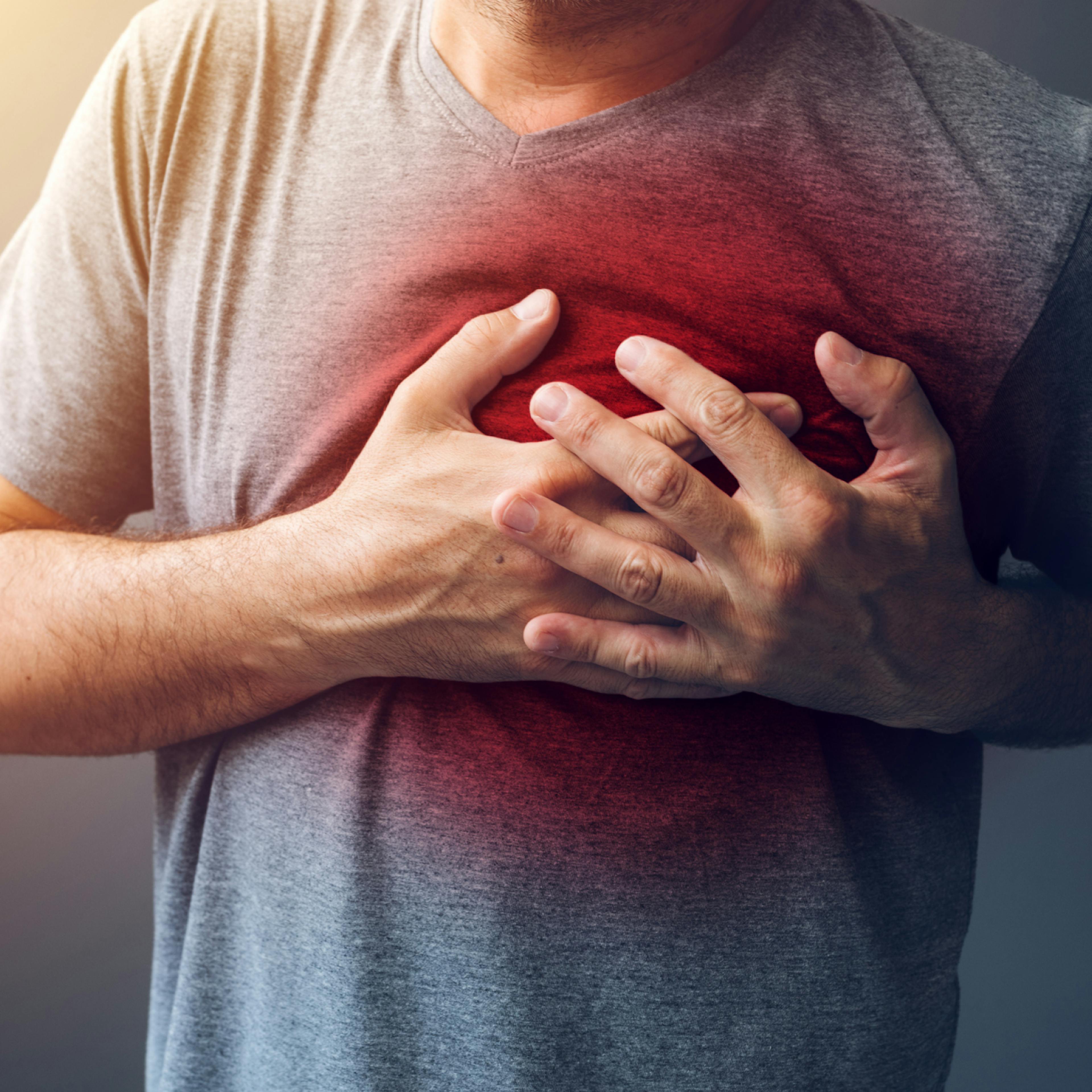 A man holding his chest due to chest pain.