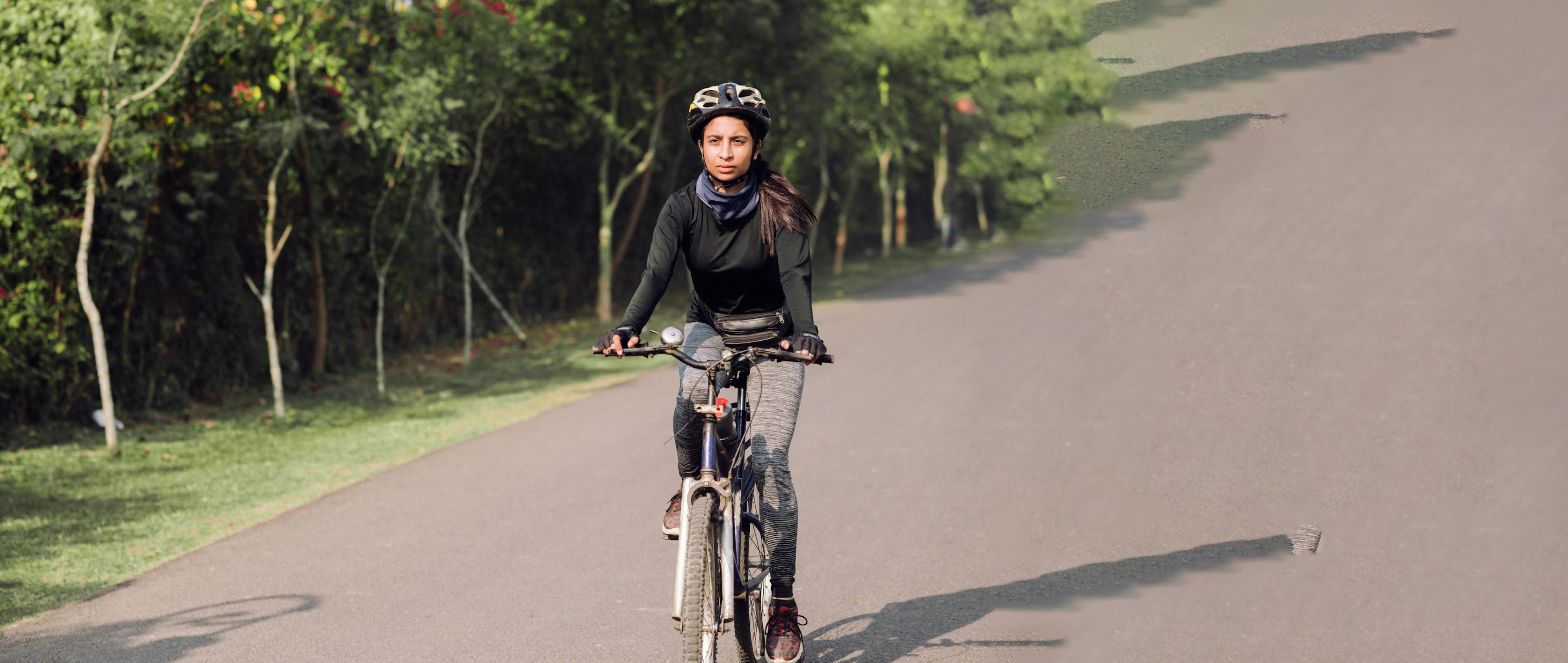 Portrait of a fit Indian female cyclist out of a training ride on her bicycle.