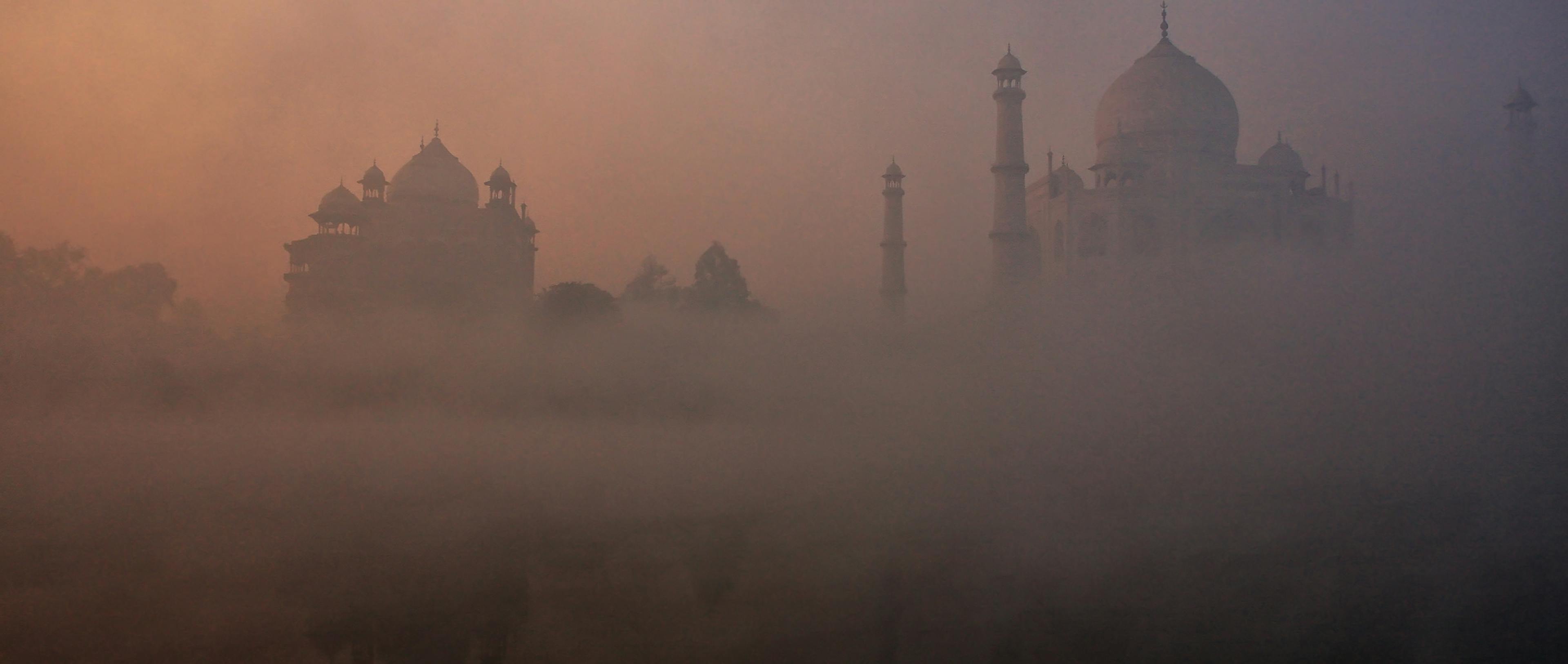 View of Taj Mahal reflected in Yamuna river with early morning fog, Agra, Uttar Pradesh, India.