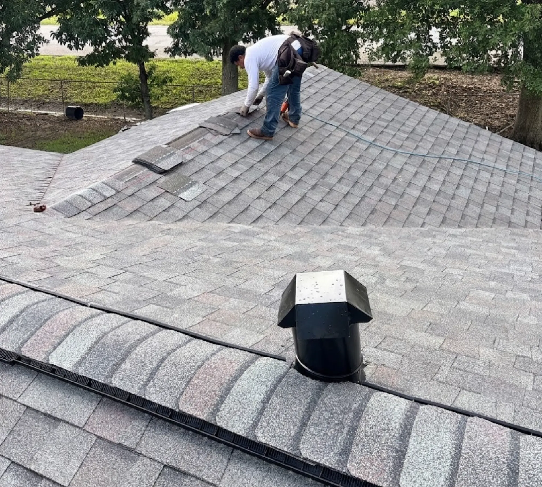 roofing contractor installing grey asphalt shingles on residential roof replacement project - Boise, ID - Flux Boise Roofing & Siding