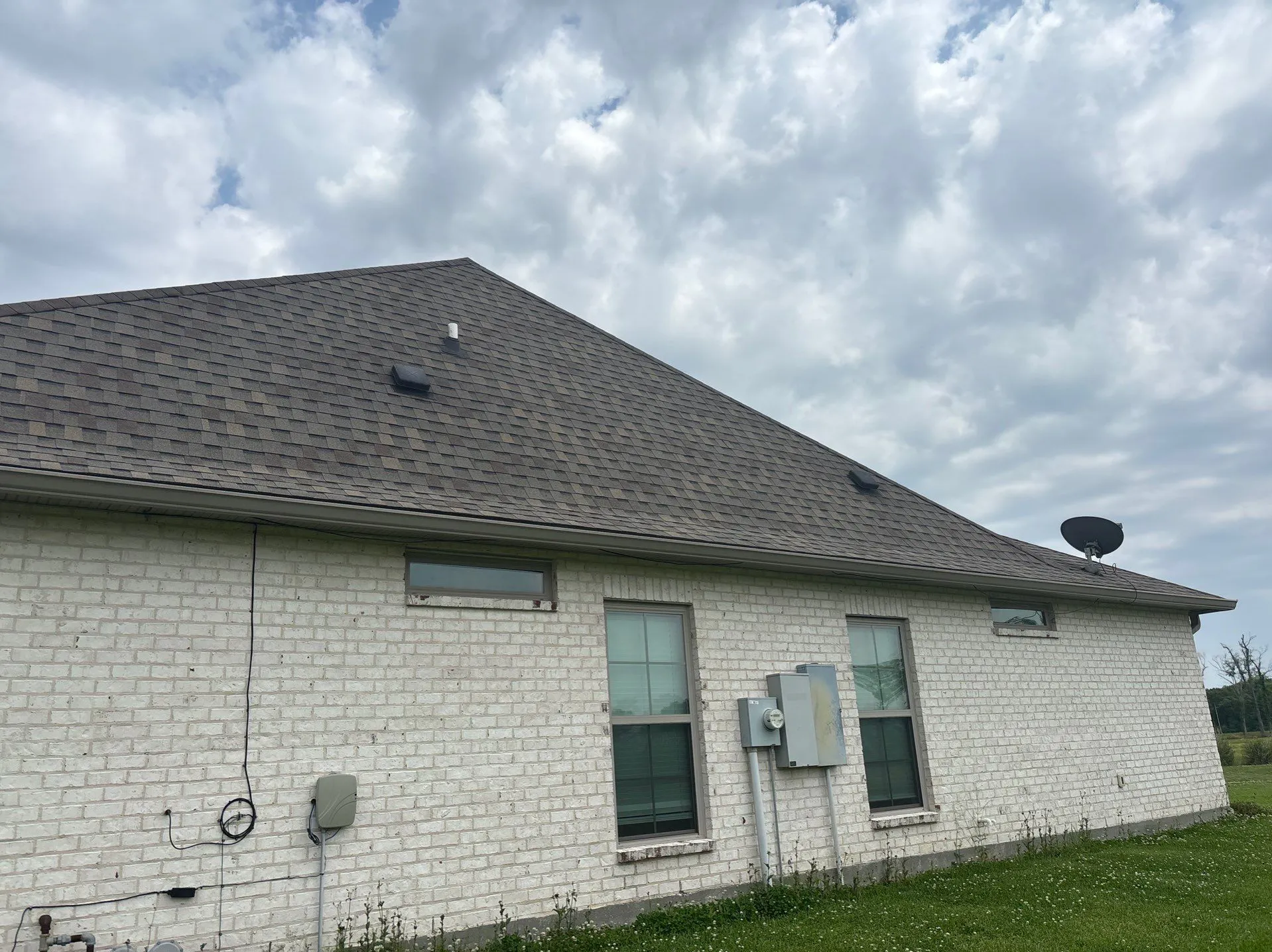residential roof installation with dark brown asphalt shingles and gutter system on brick home - Boise, ID - Flux Boise Roofing & Siding
