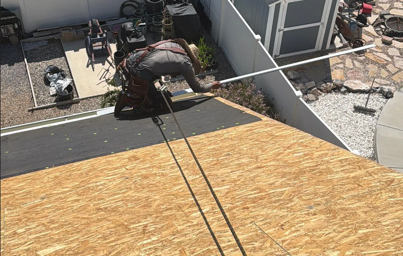 Roof worker harnessed in fixing a roof