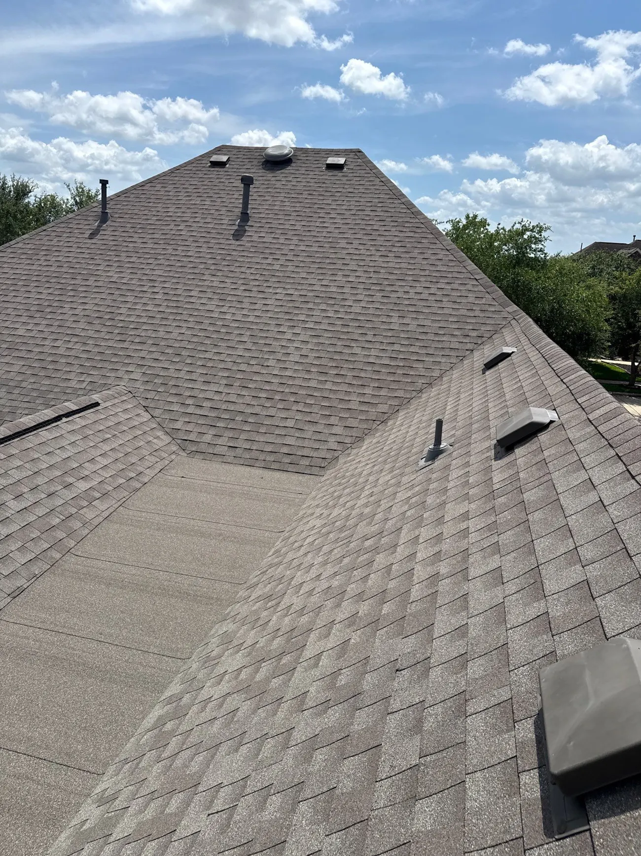 residential roof replacement with brown architectural shingles attic vents and plumbing stacks - Provo, UT - Flux Provo Roofing & Siding