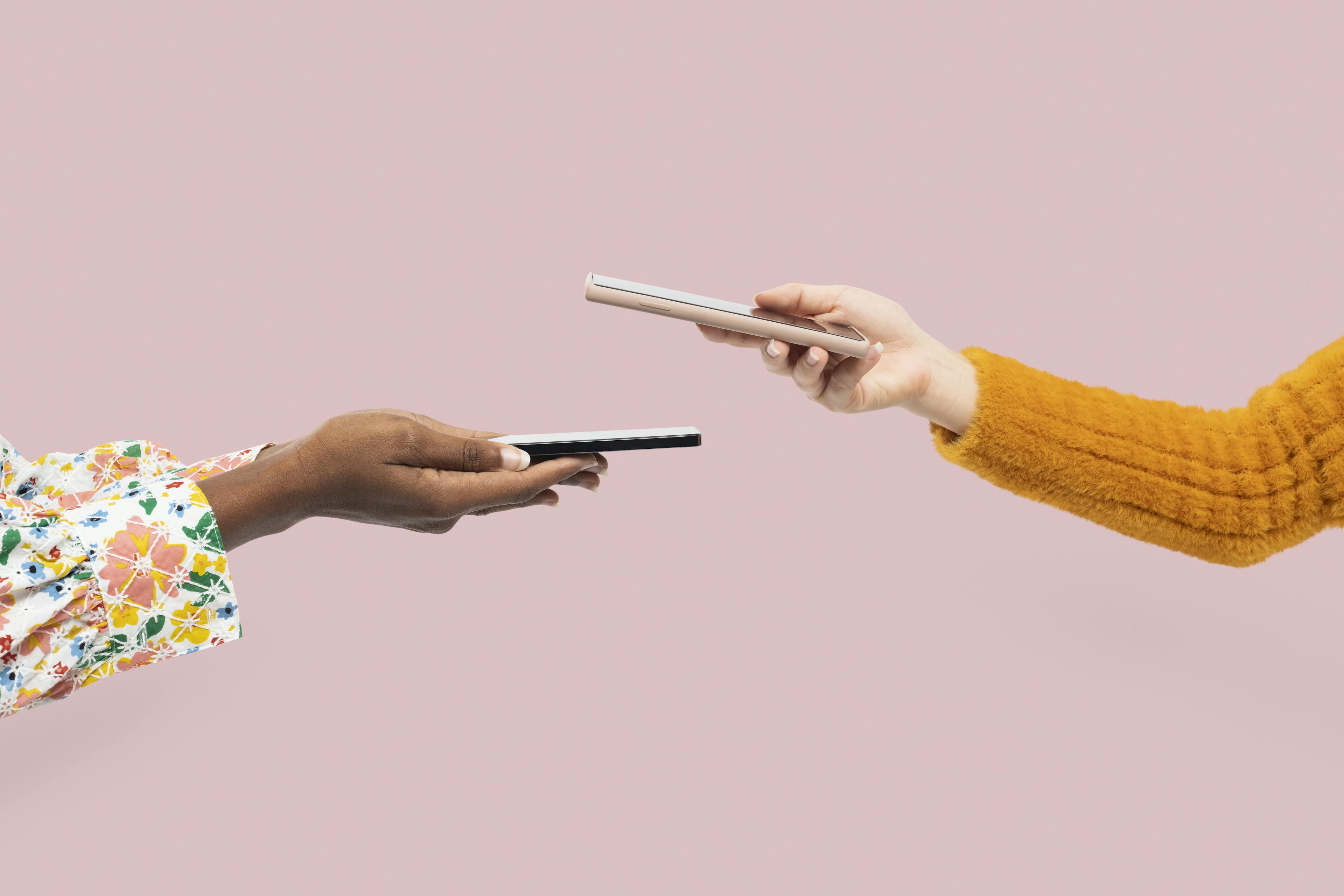 Two people tapping their phones together to process a wireless transaction