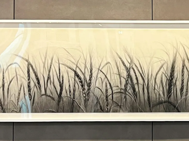 Framed monochrome artwork depicting tall wheat stalks in a softly fading gradient from dark at the base to light at the top, evoking a misty prairie field.