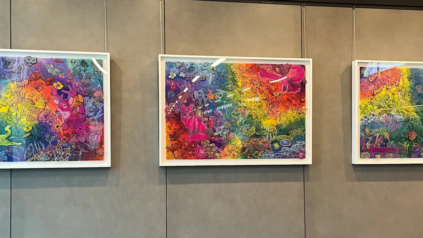 Triptych of vivid, rainbow-hued illustrations filled with whimsical animals, plants, and fantastical creatures layered in intricate detail across energetic, swirling backgrounds.