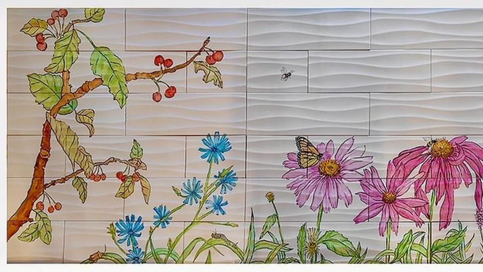 Detail of a botanical mural showing cherry branches, chicory, coneflowers, a monarch butterfly, and a bee, set against sculpted white tiles.