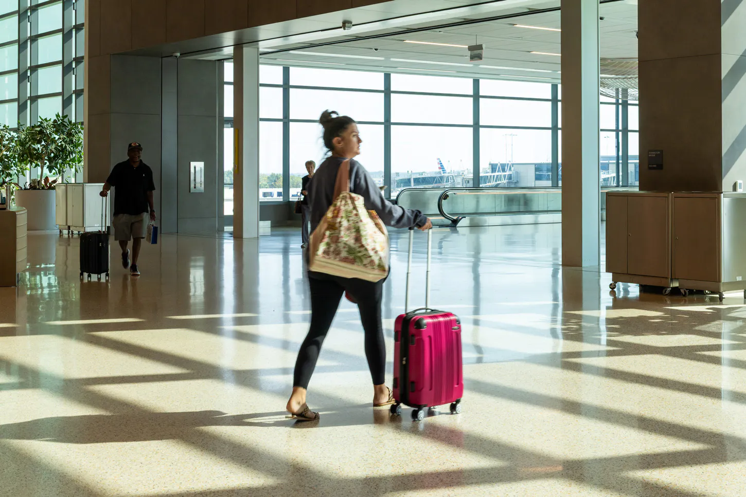 A traveler is walking towards the connector to the B concourse.
