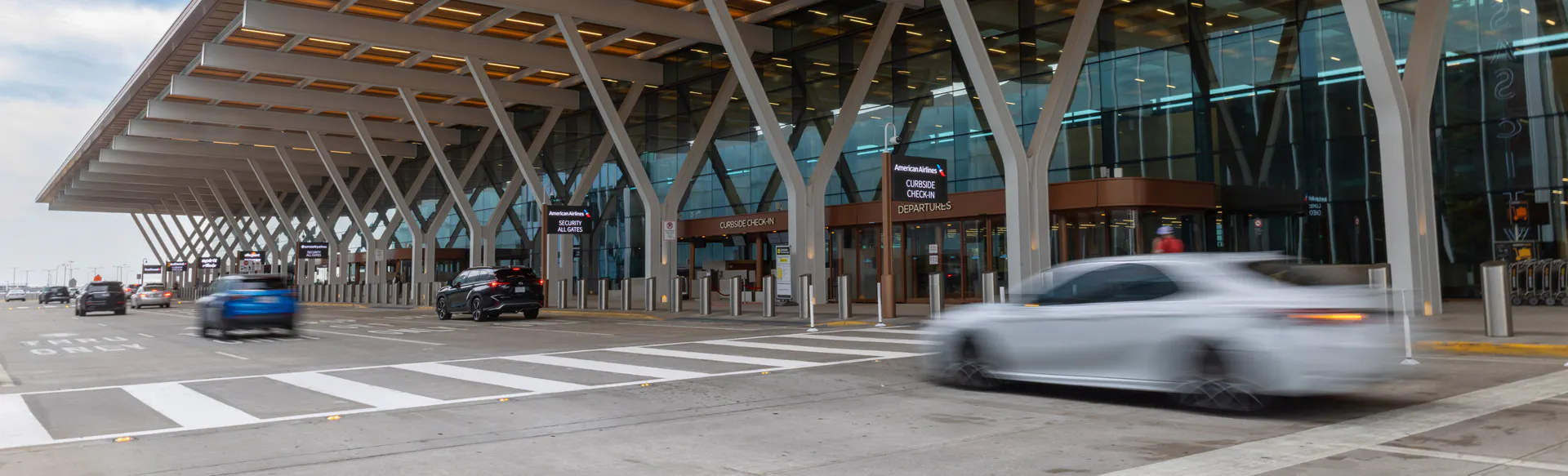 A car is driving by the departures curb at Kansas City International airport.
