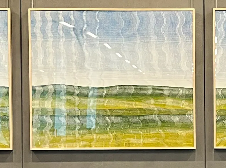 Four-panel landscape artwork featuring abstract horizontal bands of green, yellow, and blue tones, resembling rolling hills beneath a bright sky with a wavy, reflective texture.