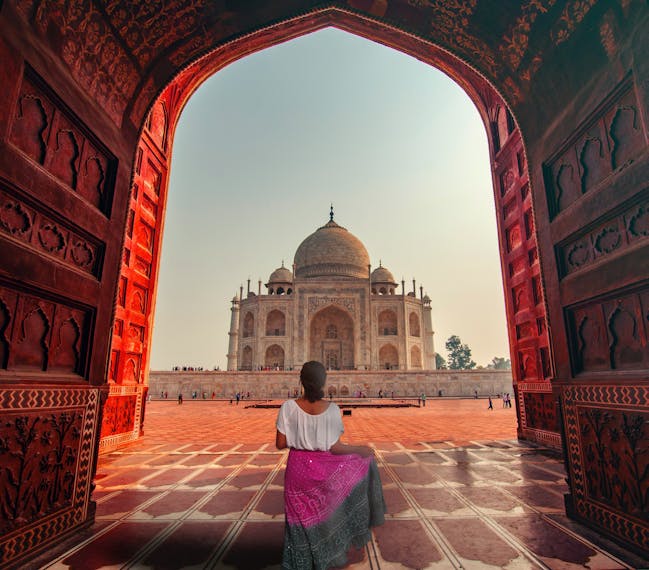 Eine Frau steht vor dem Taj Mahal. 