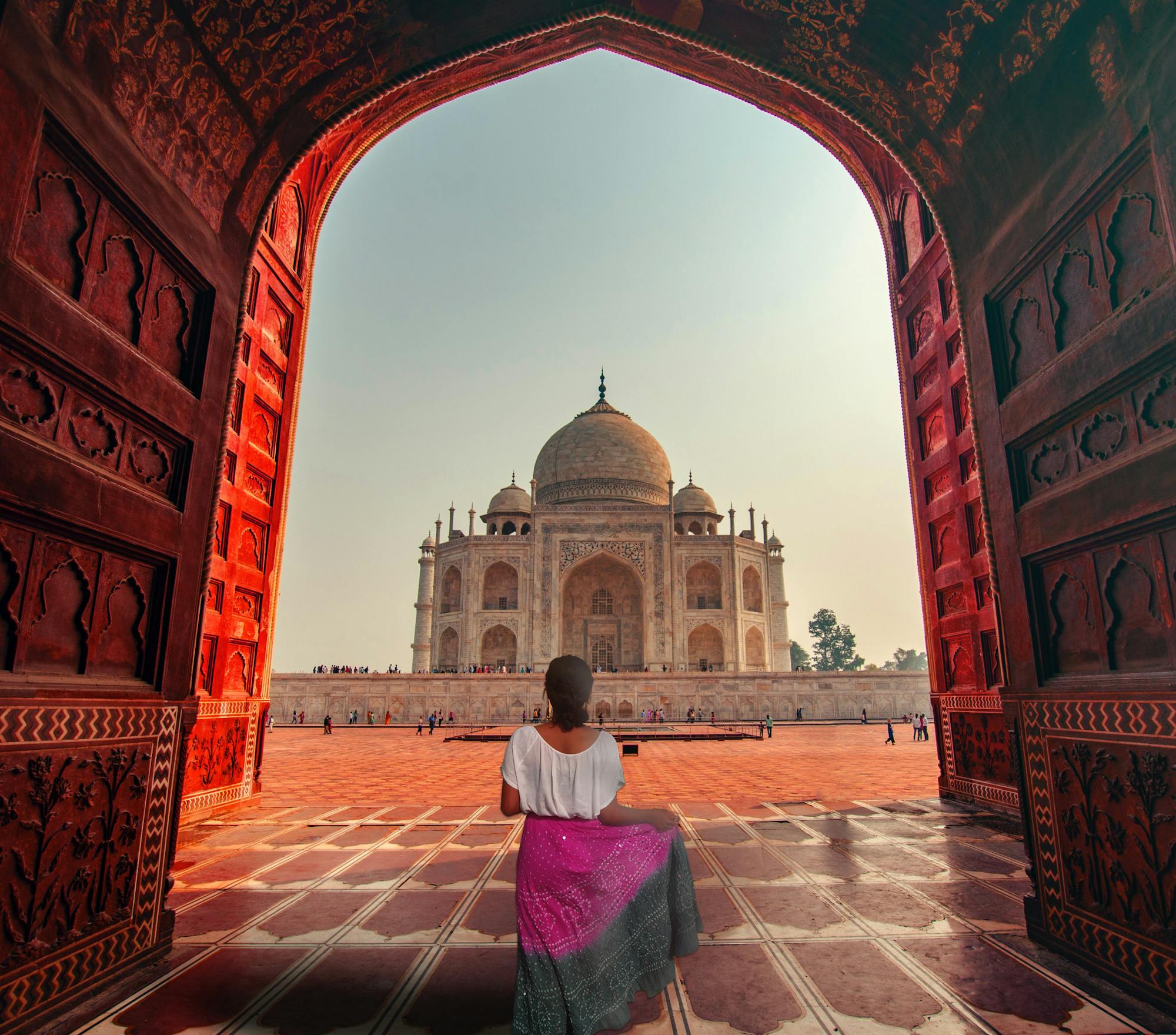 Eine Frau steht vor dem Taj Mahal. 