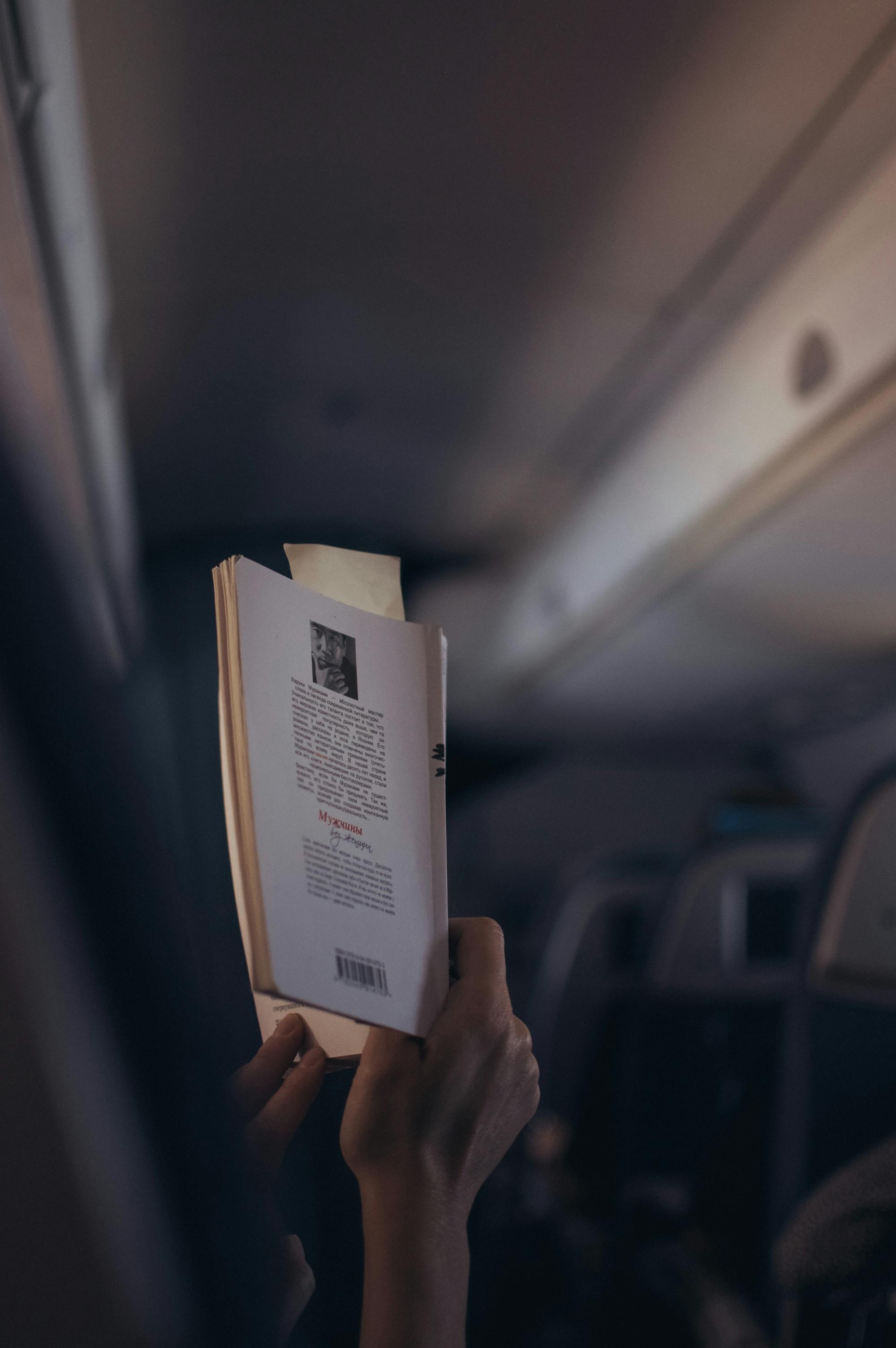 Pasażer czyta swoją książkę w samolocie.