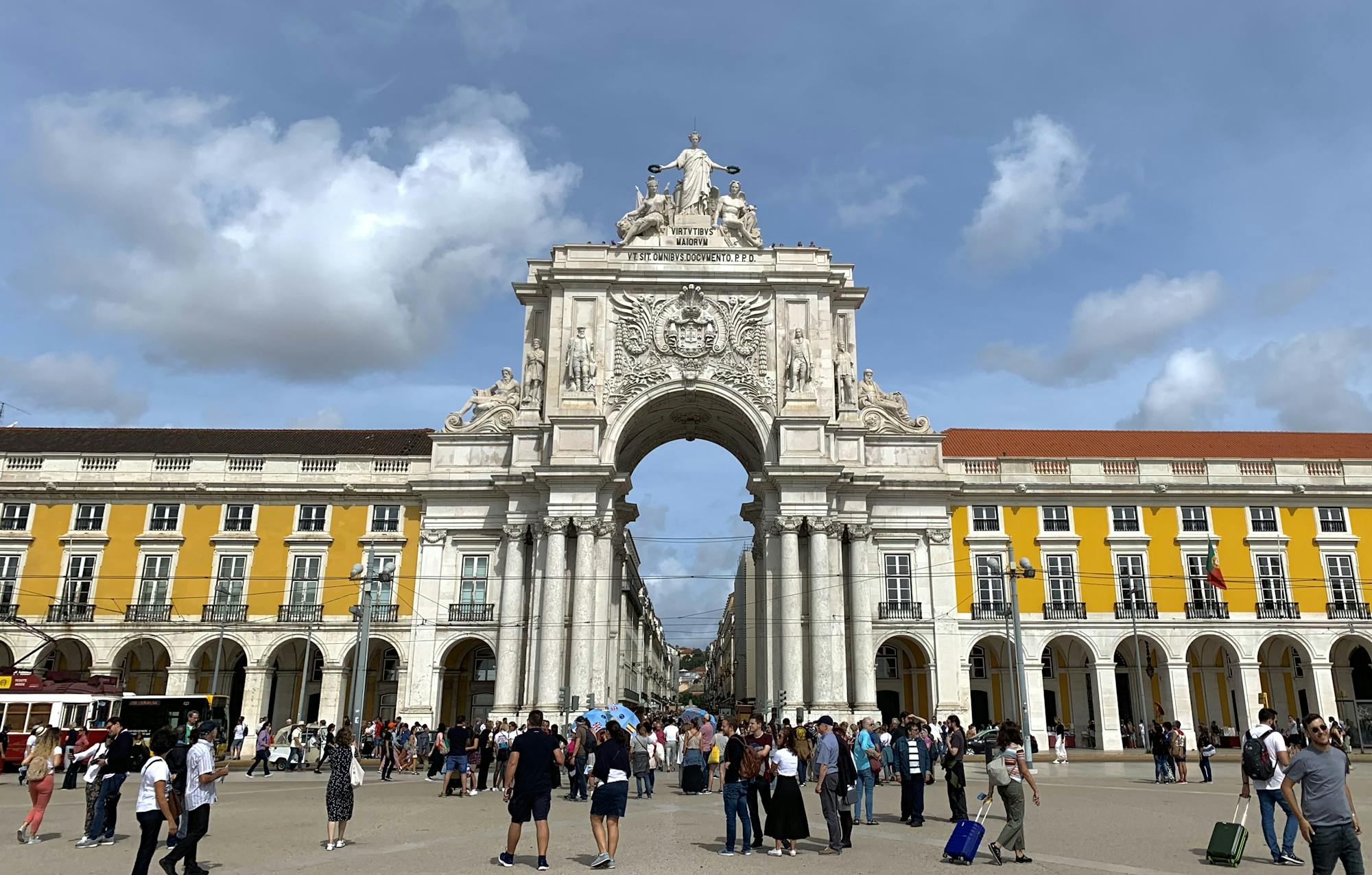 Viele Menschen laufen durch den Triumphbogen, um in die Einkaufsstraßen Lissabons zu gelangen. 