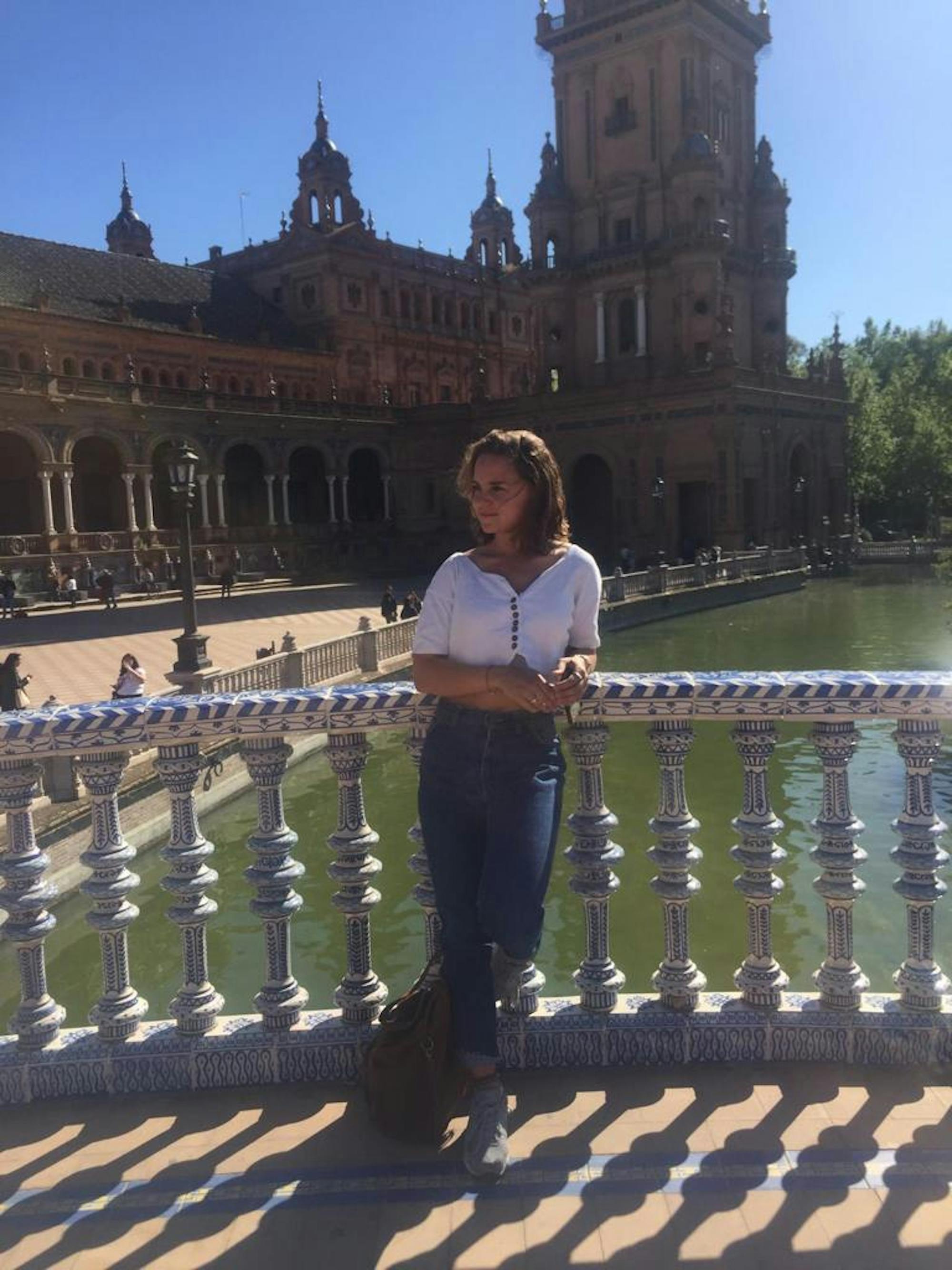 Corinna steht auf einer der schönen Brücken in Sevilla. 