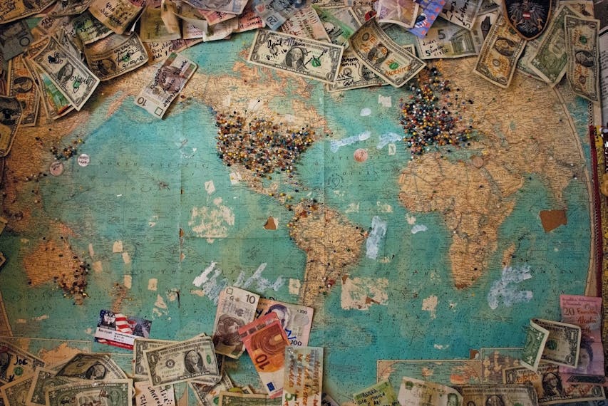 Mapa świata, na której znajduje się wiele banknotów z różnych krajów