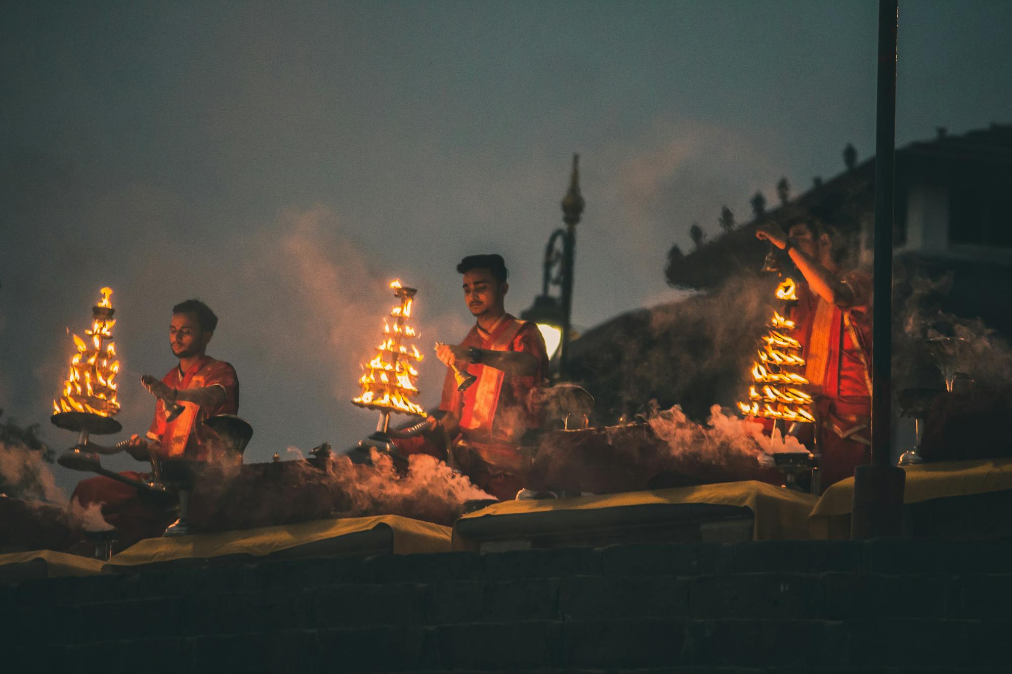 indische Traditionen: Männer in traditionell indischer Kleidung halten Feuerstäbe in die Luft.