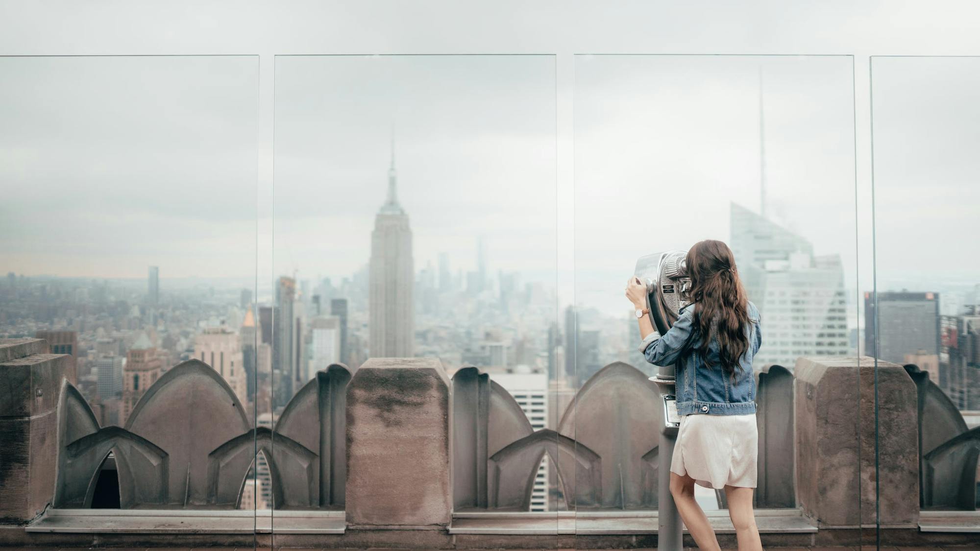 Młoda kobieta stoi na tarasie widokowym w Nowym Jorku