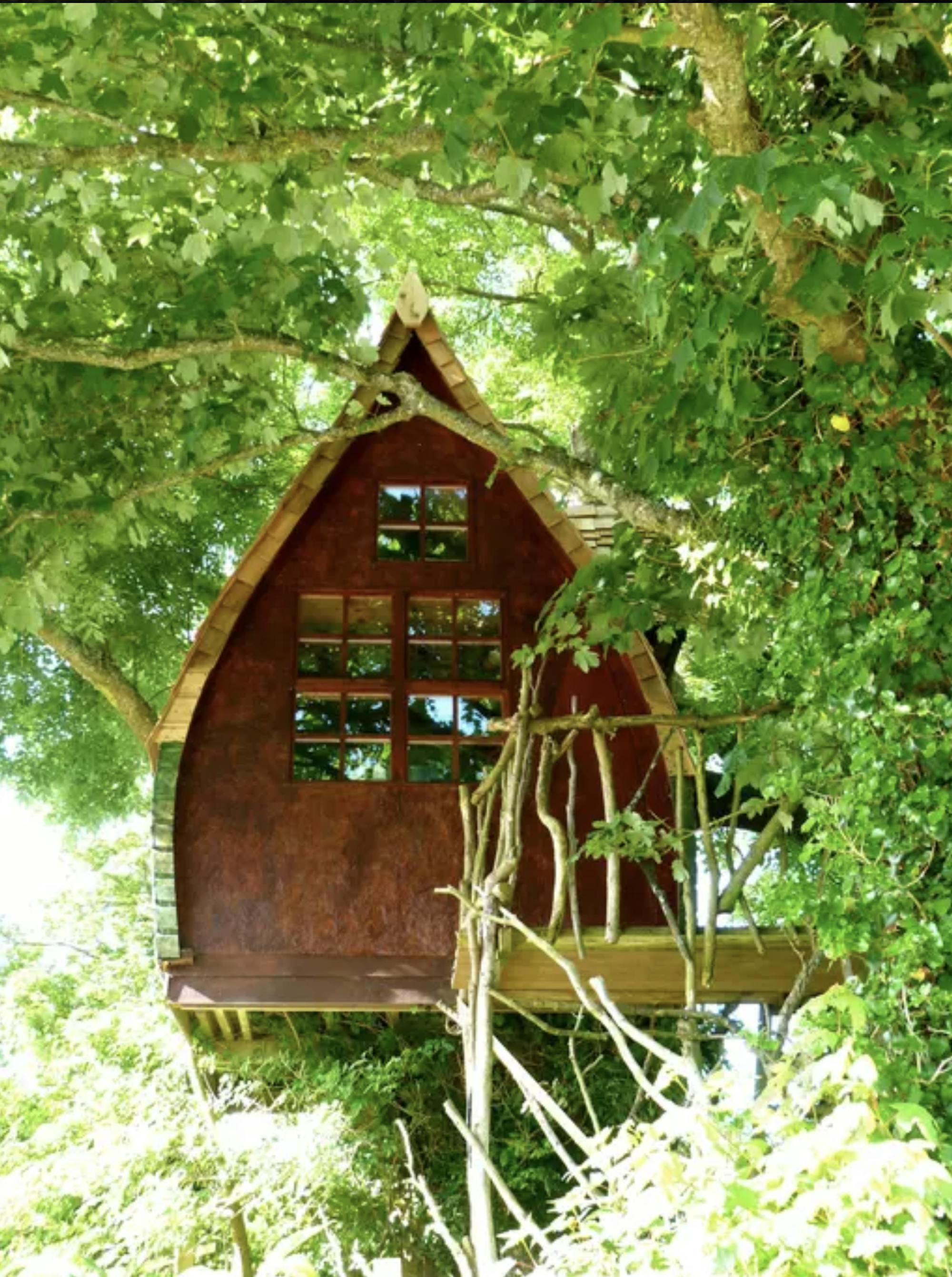 Das Baumhaus befindet sich mitten in der Natur, umgeben von zahlreichen Bäumen. Die Form des kleinen Baumhauses ähnelt an ein kleines, süßes Hexenhaus. 