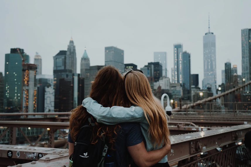 Dwie kobiety, które się przytulają, patrzą na panoramę Nowego Jorku