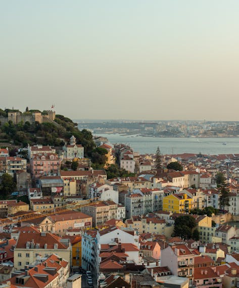 Ausblick auf die Stadt Lissabon, ihre bunten Häuser sowie den Fluss Tejo 