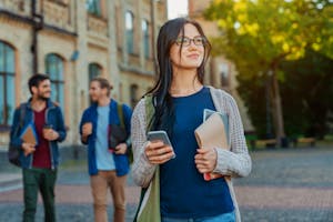 Studentin schaut auf dem Campus in die Ferne