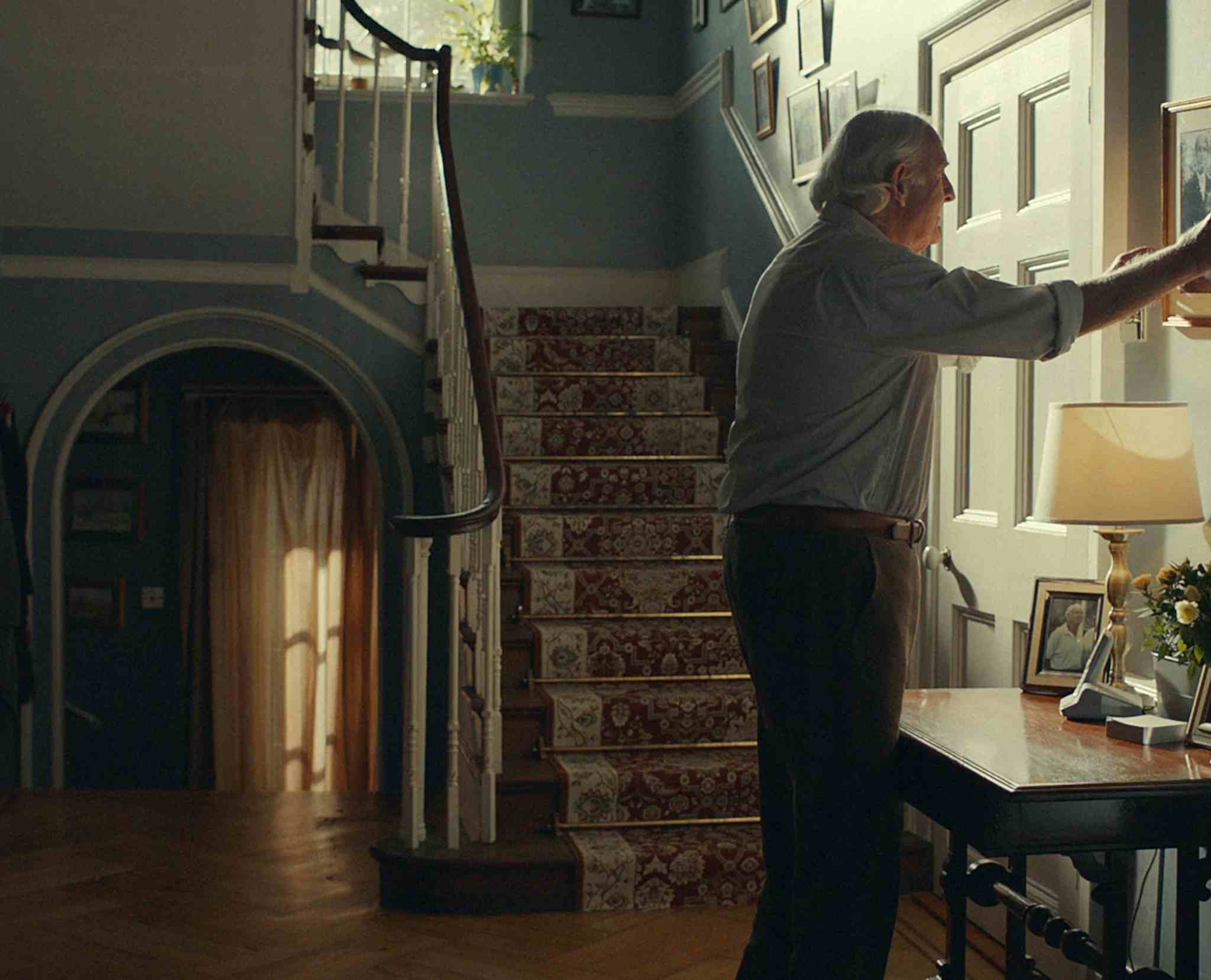 Man hanging a photo in a house - Rightmove Life Steps campaign