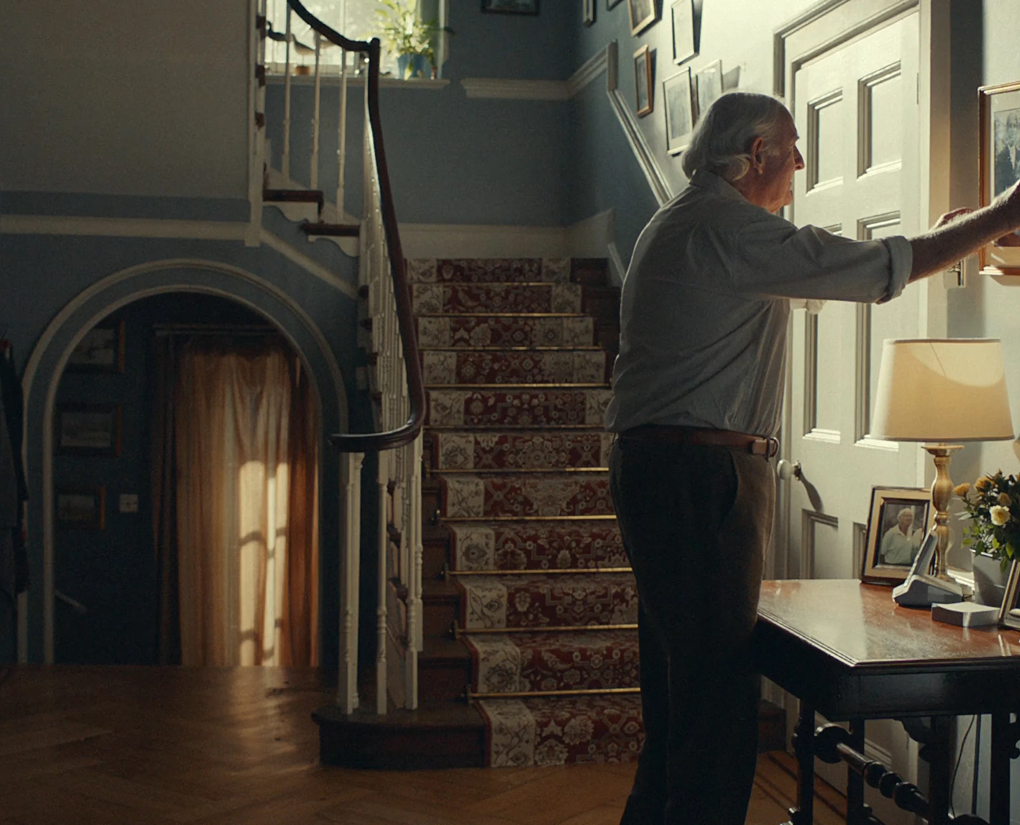 Man hanging a photo in a house - Rightmove Life Steps campaign