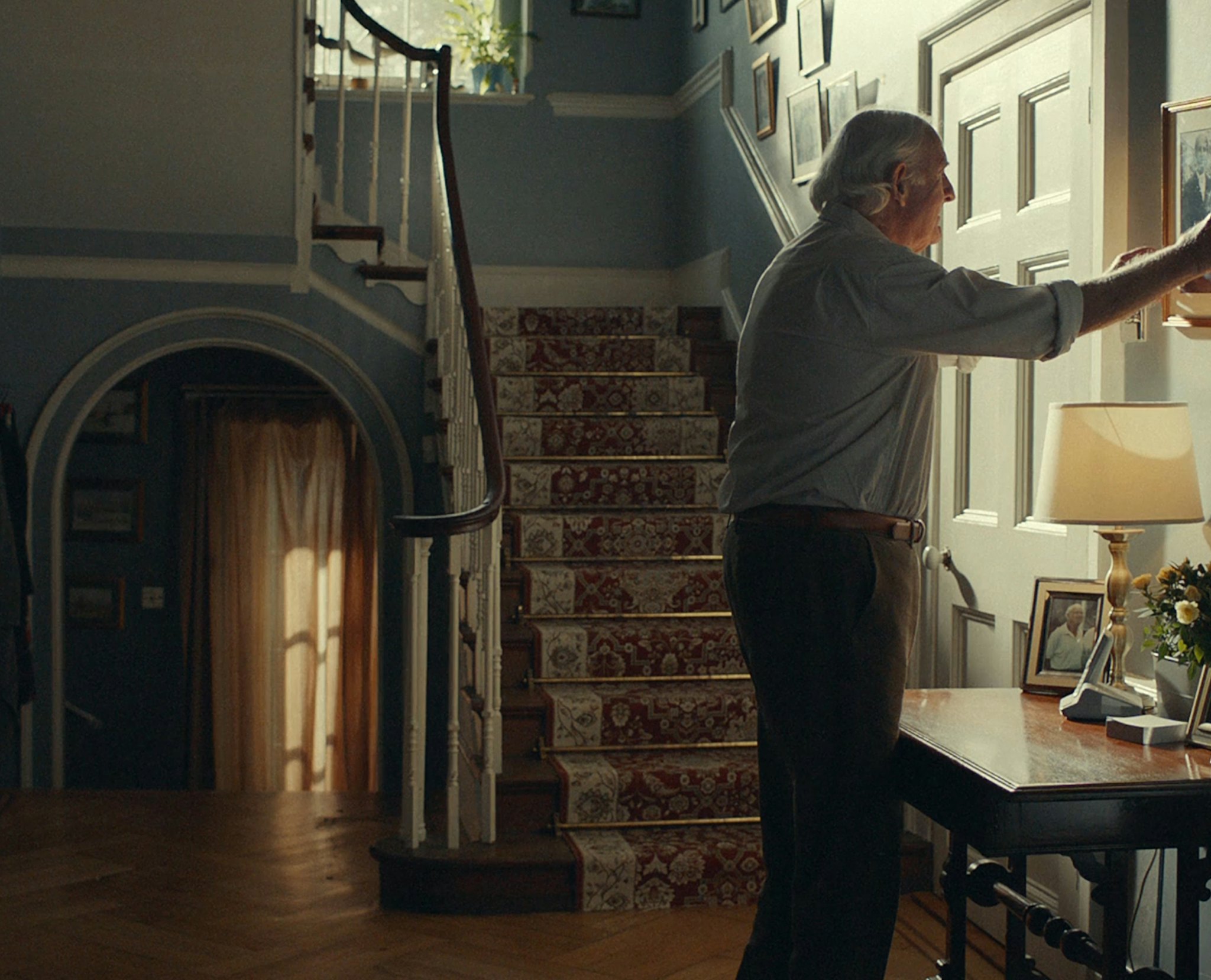 Man hanging a photo in a house - Rightmove Life Steps campaign