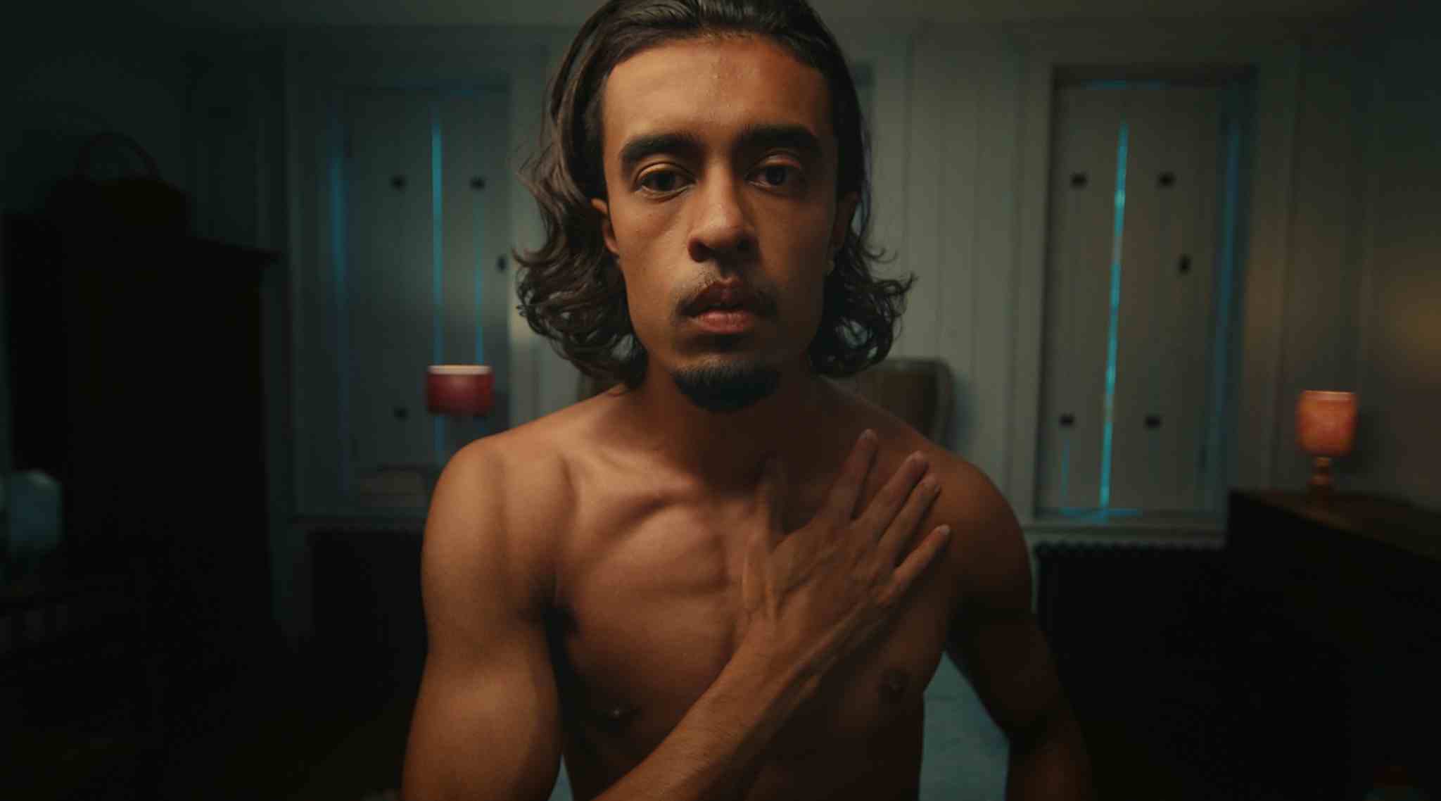 Bare chested man with a hand on heart