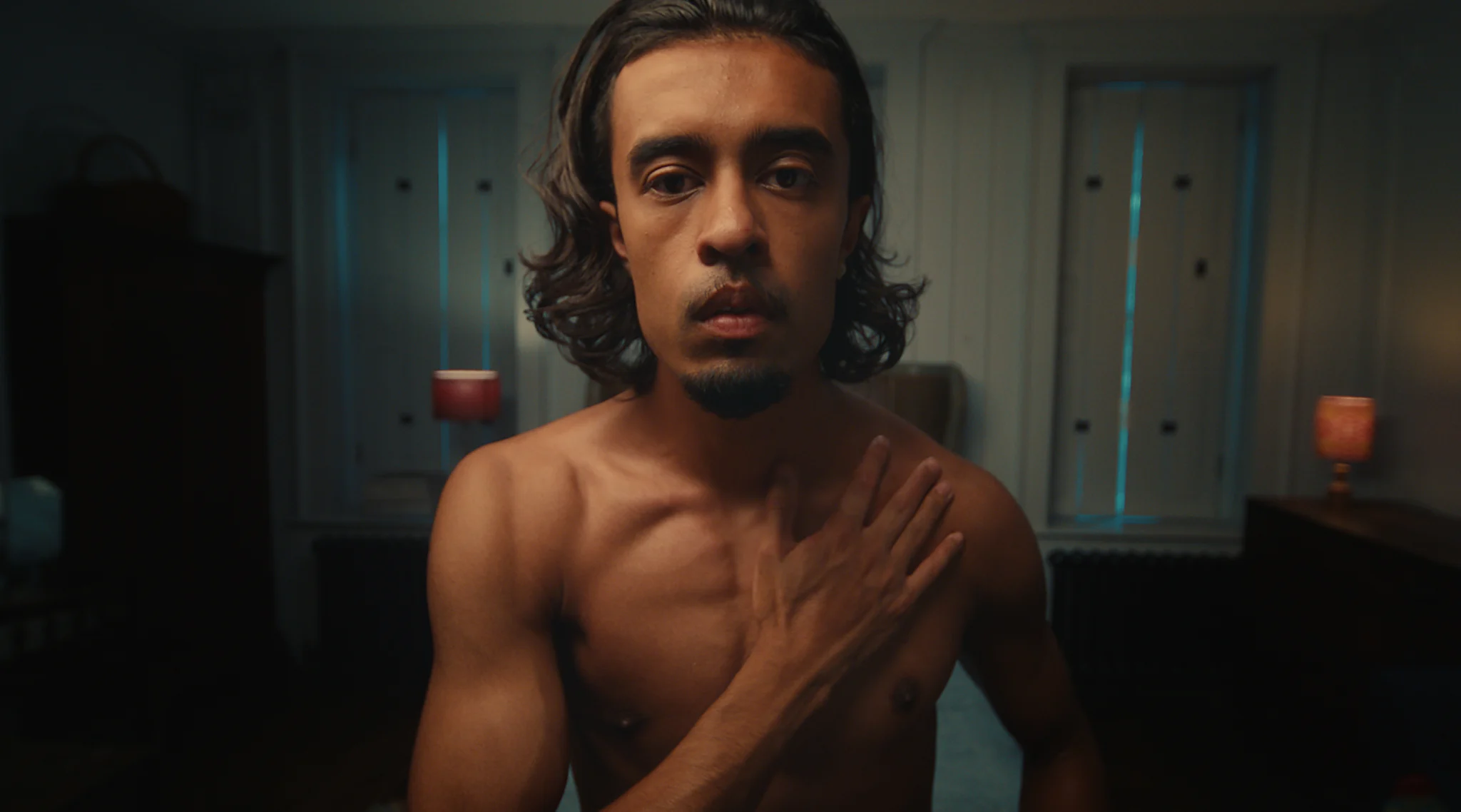 Bare chested man with a hand on heart