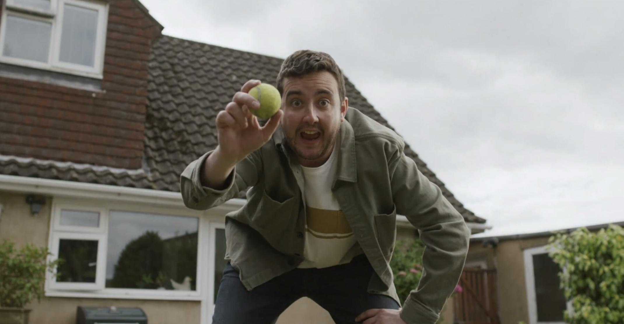 A Man Holding a Tennis Ball outside a house - Capital One No Nasty Surprises Campaign