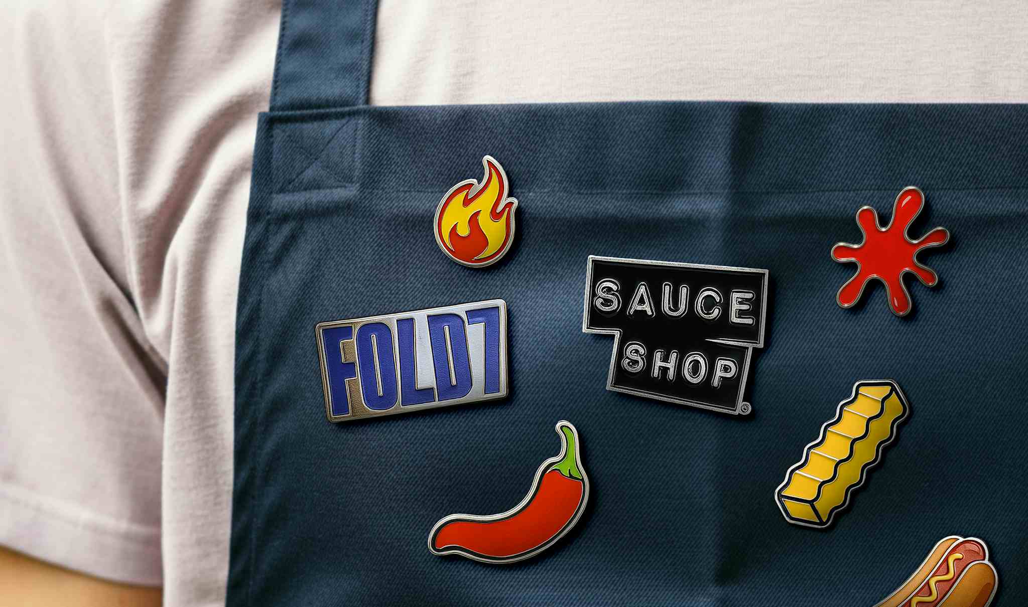 Image of an apron with sauce shop & fold7 logo badges